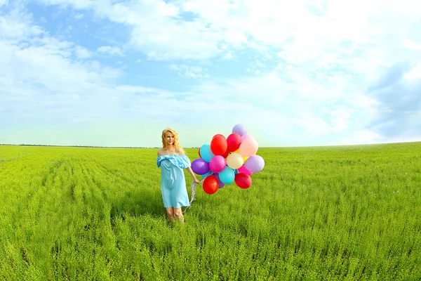 Счастливая женщина с цветными воздушными шарами — стоковое фото