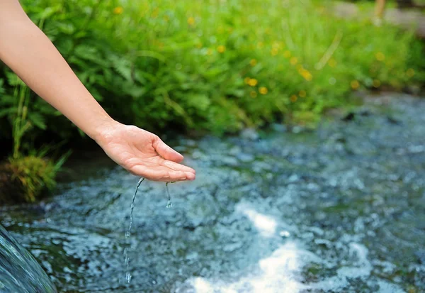 Hand in de buurt van water stroom — Stockfoto