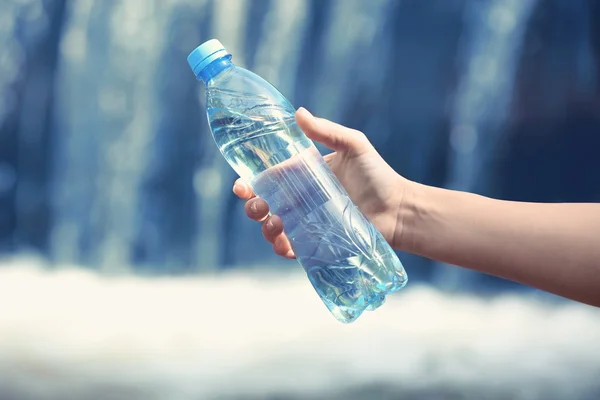 Woman hand holding bottle with water — Stock Photo, Image