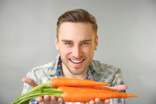 Hombre guapo con zanahorias — Foto de Stock