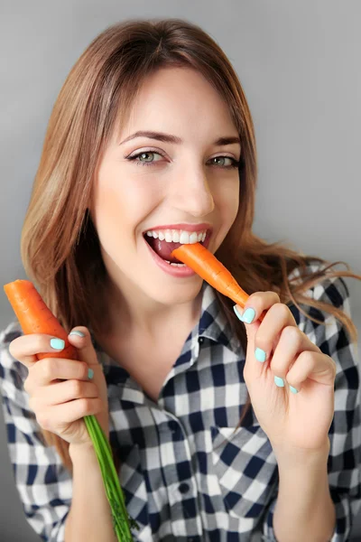 Beautiful girl eating carrot — Stock Photo, Image