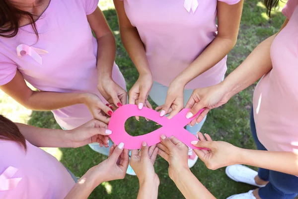 Manos femeninas sosteniendo cinta rosa — Foto de Stock