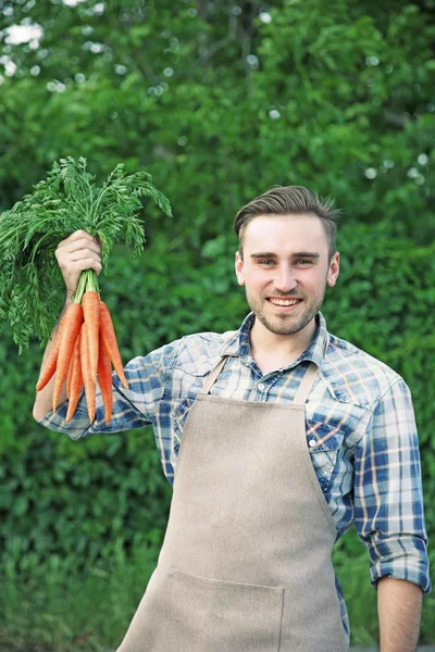 Homem bonito com cenouras — Fotografia de Stock