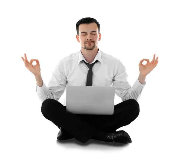 Businessman with laptop relaxing in meditation pose, isolated on white