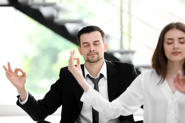 Business people relaxing in meditation pose