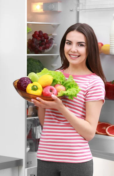 Молодая женщина и холодильник — стоковое фото