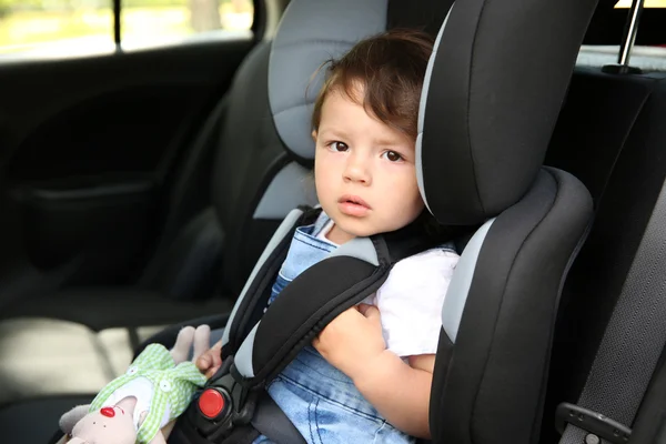 Menino sentado em um carro em cadeira de segurança — Fotografia de Stock