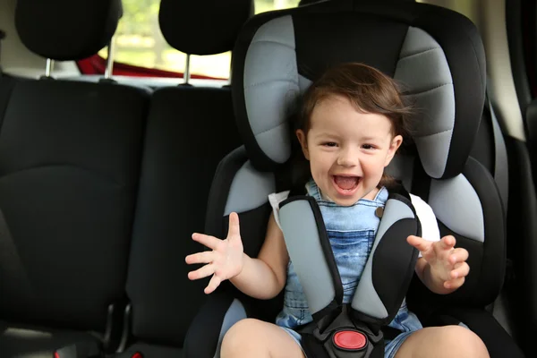 Menino sentado em um carro em cadeira de segurança — Fotografia de Stock