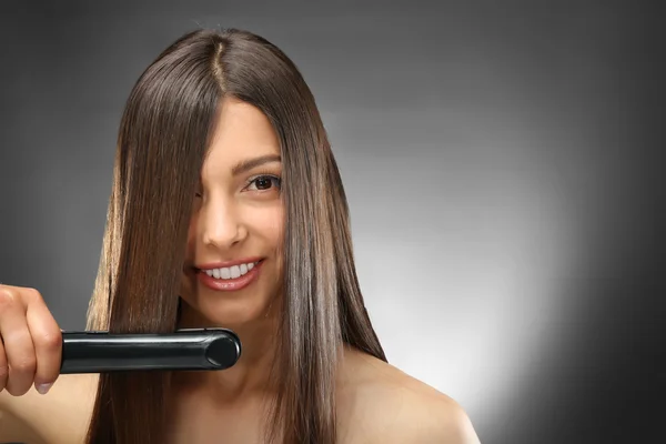 woman straightening hair