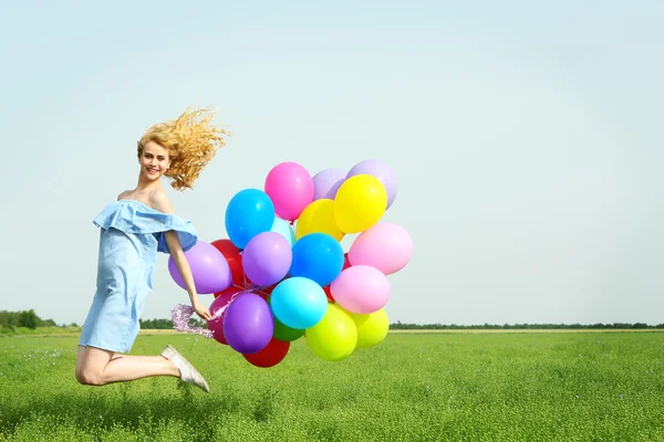 Šťastná žena s barevnými balónky — Stock fotografie