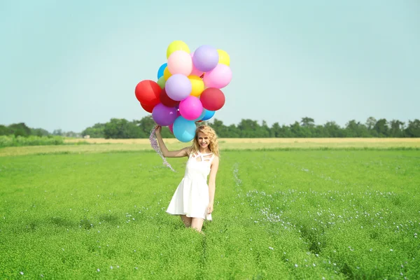 Glad kvinna med färgglada ballonger — Stockfoto