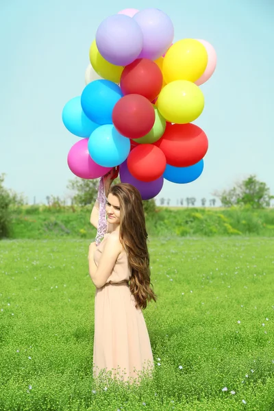 Glückliche Frau mit bunten Luftballons — Stockfoto