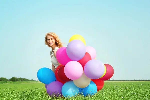 Ευτυχισμένη γυναίκα με πολύχρωμα μπαλόνια — Φωτογραφία Αρχείου
