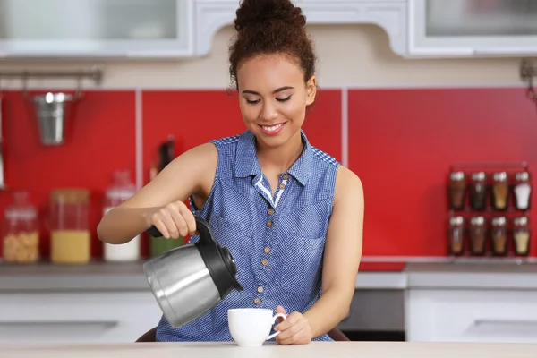 Женщина делает кофе на кухне — стоковое фото