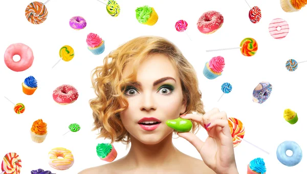 Красива дівчина з барвистими льодяниками, пончиками та кексами на світлому фоні — стокове фото