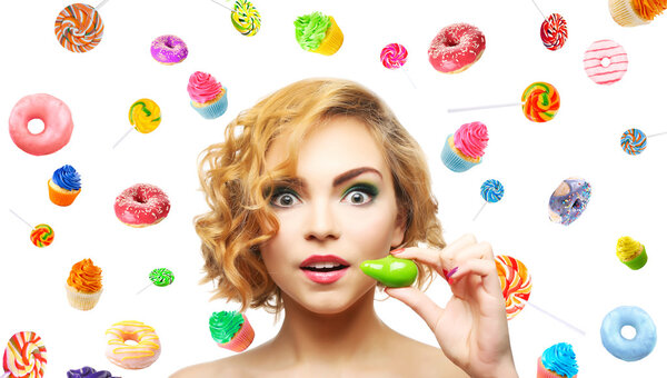 Beautiful girl with colorful lollipops , donuts and cupcakes on light background