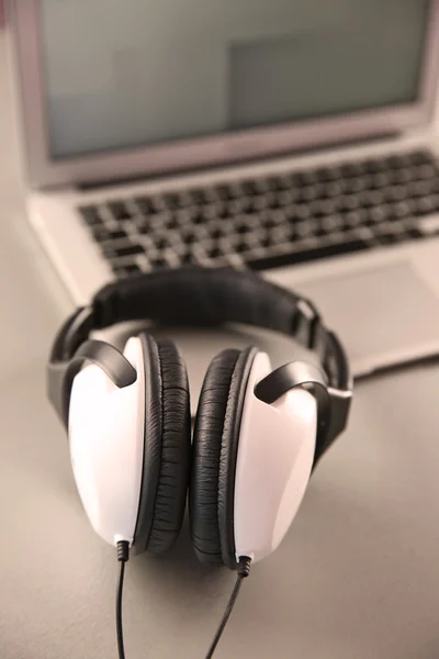 Fones de ouvido e laptop na mesa closeup — Fotografia de Stock