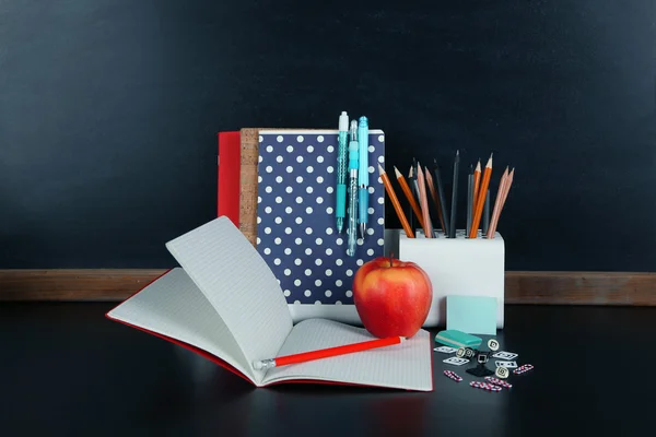 School supplies near blackboard — Stock Photo, Image