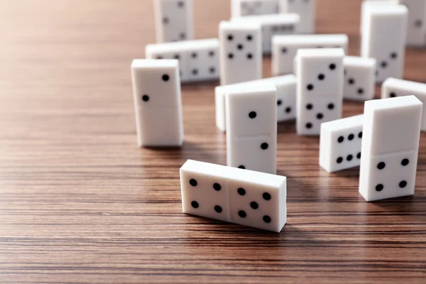 Högen av dominobrickor på trä bakgrund — Stockfoto