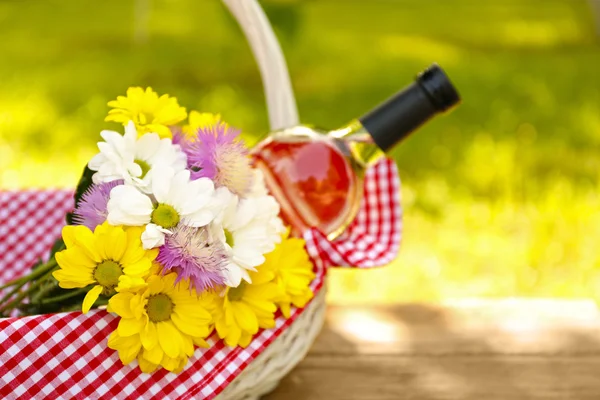 Bouteille de vin avec fleurs dans le panier — Photo