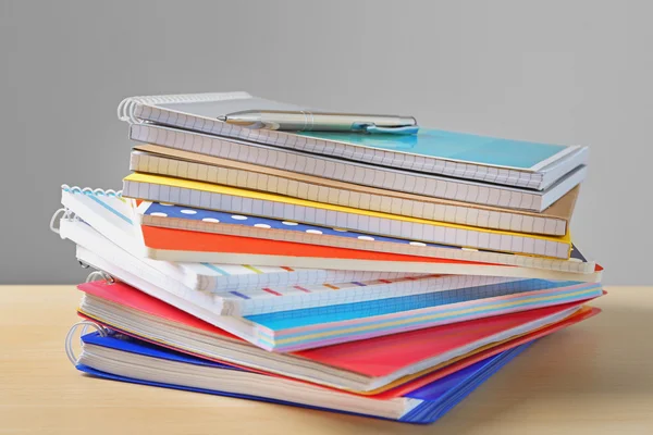 Cuadernos escolares y bolígrafo sobre mesa — Foto de Stock