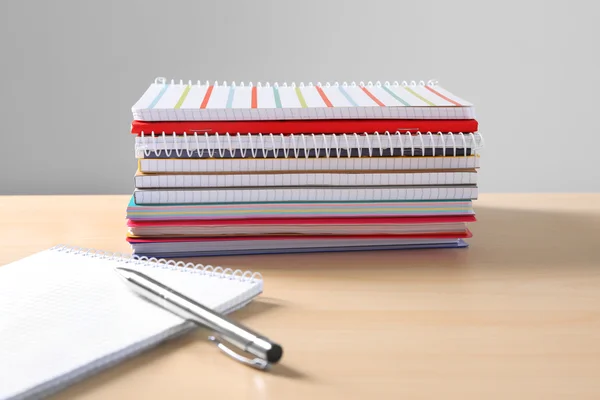 Cuadernos escolares y bolígrafo sobre mesa — Foto de Stock