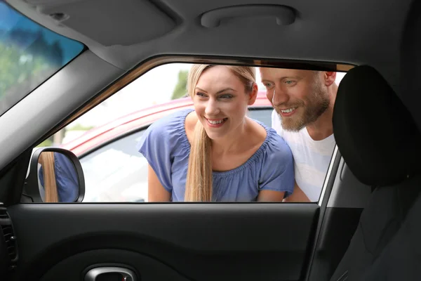 Mladý pár hledá uvnitř automobilu — Stock fotografie