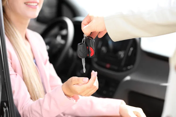 Vendeur donnant la clé de voiture au client — Photo