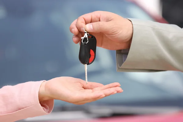 Verkoper auto sleutel geven aan klant — Stockfoto