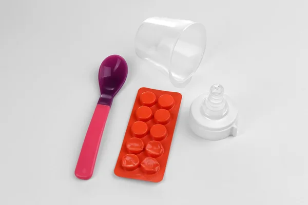 Baby bottle nipple with pills and spoon — Stock Photo, Image