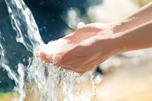 Water dropping from woman's hands — Stock Photo, Image