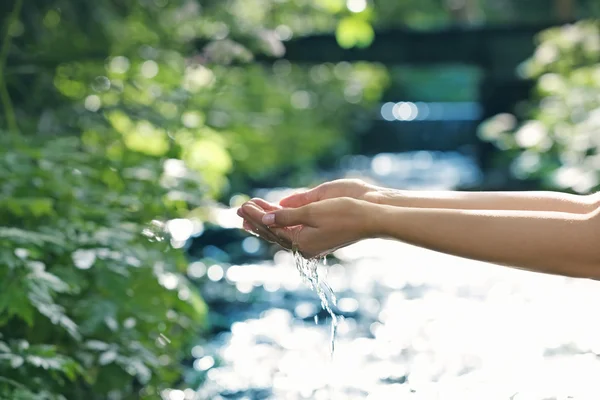 Acqua che cade dalle mani della donna — Foto Stock