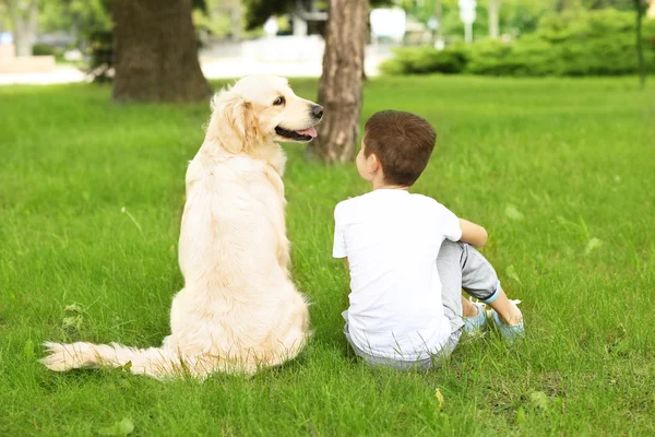 Petit garçon et chien dans le parc — Photo