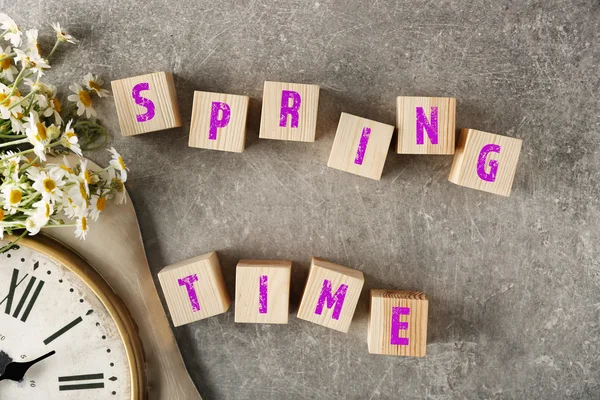 Wooden cubes, clock and chamomiles — Stock Photo, Image