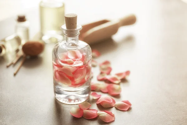 Bouteille avec pétales de rose — Photo