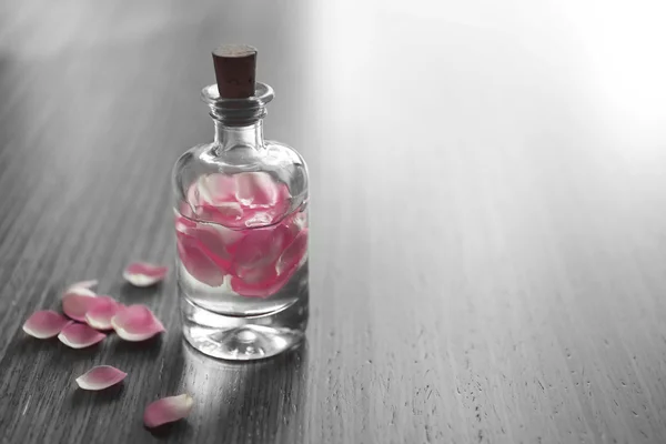 Bottle with rose petals — Stock Photo, Image