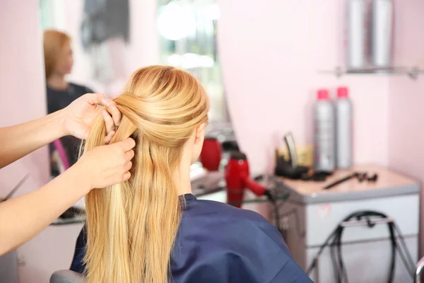 Friseur flechtet Frau die Haare — Stockfoto