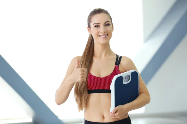 Jonge vrouw met vloer weegschalen — Stockfoto