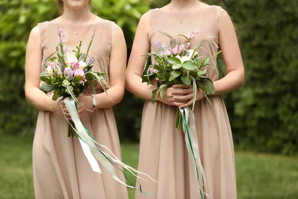 Hermosas damas de honor sosteniendo ramos —  Fotos de Stock