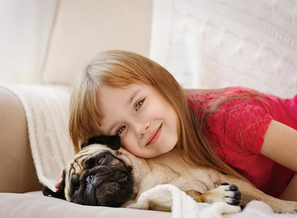 Klein meisje en schattige Mops — Stockfoto