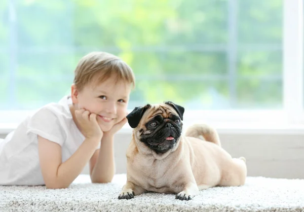 Netter Junge Mit Mops Auf Teppich Liegend — Stockfoto