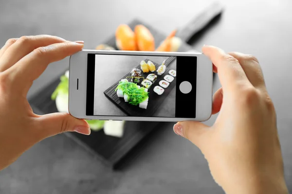 Female hands taking photo of sushi — Stock Photo, Image