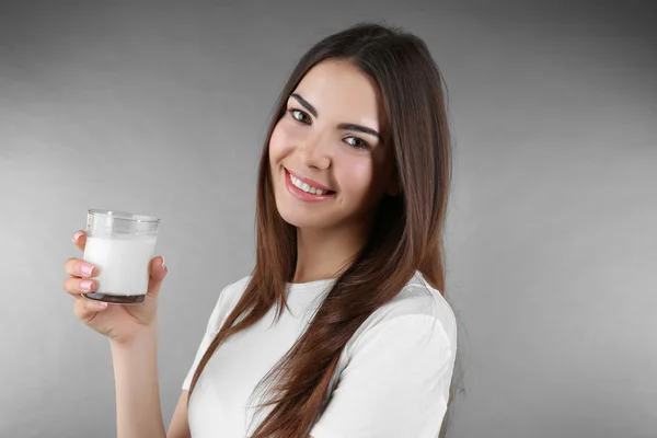 Vacker kvinna med glas mjölk — Stockfoto