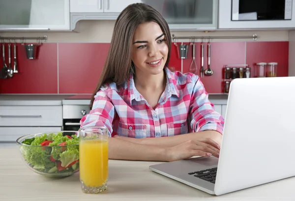 Mujer joven con portátil y jugo — Foto de Stock