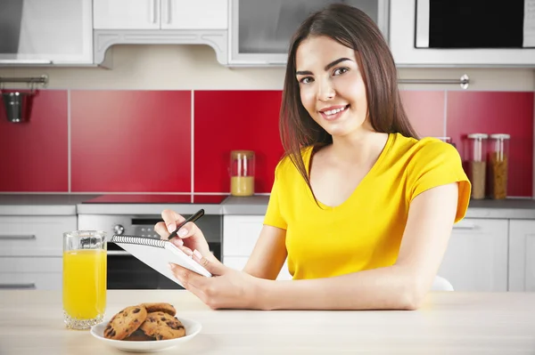 Femme assise à la table de cuisine — Photo