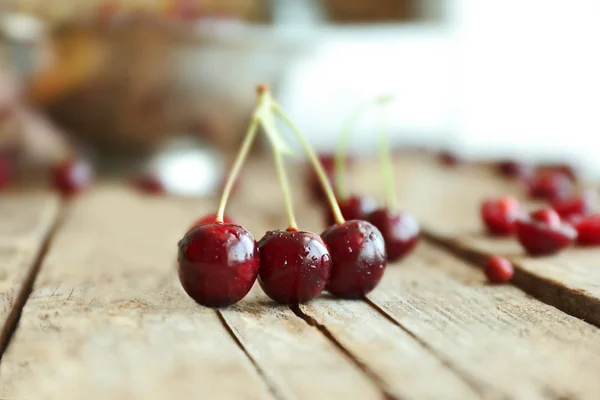 Few cherries on wooden table — Stock Photo, Image