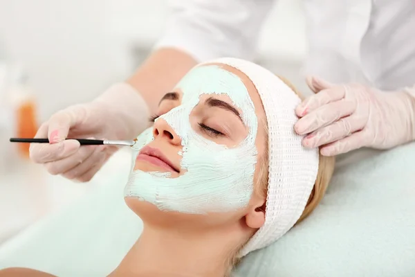 Cosmetologist applying facial mask — Stock Photo, Image