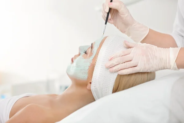 Cosmetologist applying facial mask — Stock Photo, Image