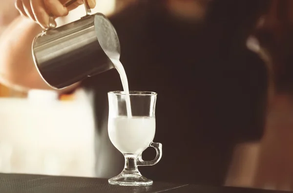 Mujer manos vertiendo leche en el vaso — Foto de Stock