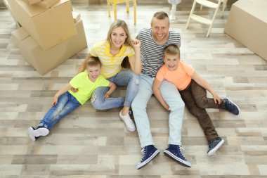 Karton kutular ahşap katta oturan ile mutlu aile